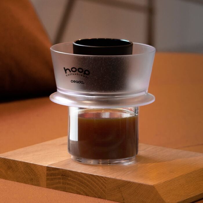 Coffee filter with a glass of coffee on a wooden surface